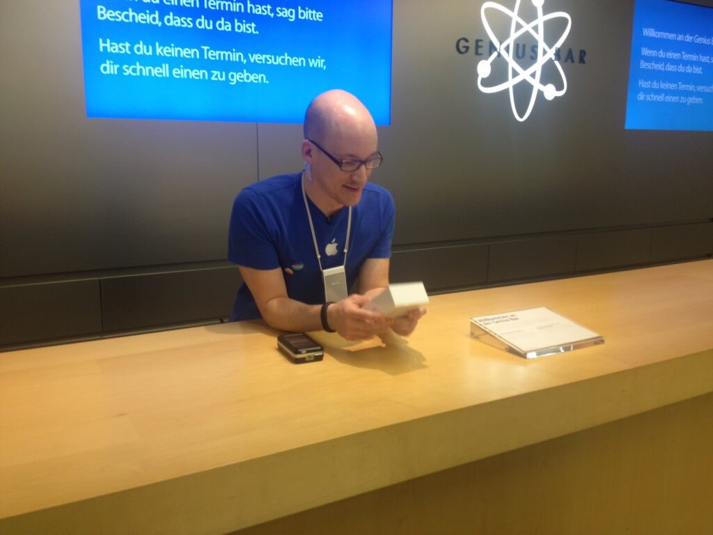 Сотрудник Apple Store держит в руках коробку с iPhone 6